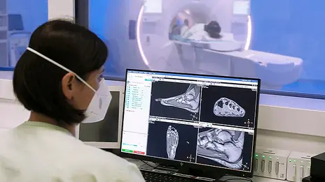 Eine Mitarbeiterin der Radiologie sieht sich Untersuchungsergebnisse auf einem Monitor an. 