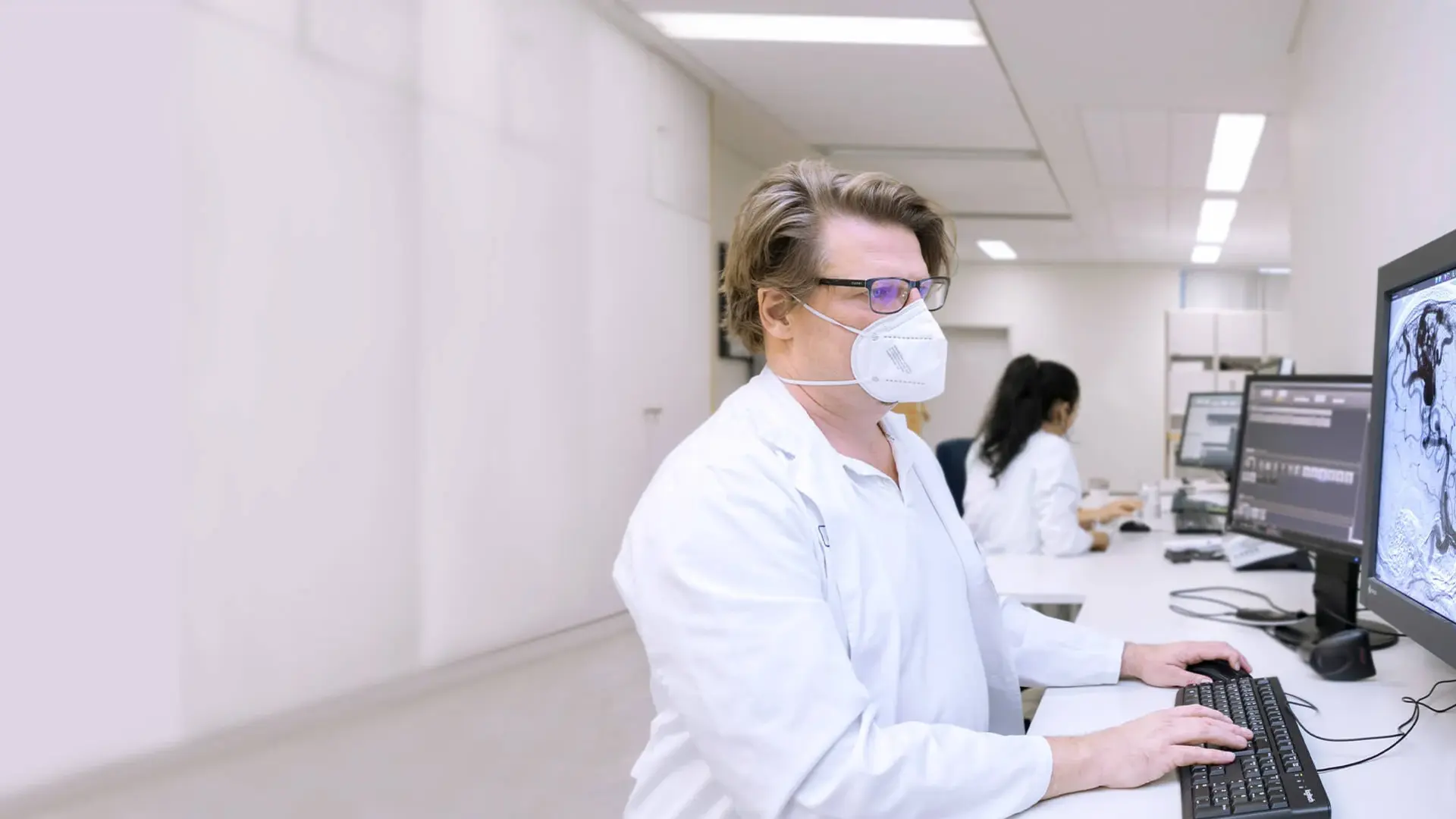 Ein Arzt der Neuroradiologie betrachtet Aufnahmen von Malformationen am Monitor.