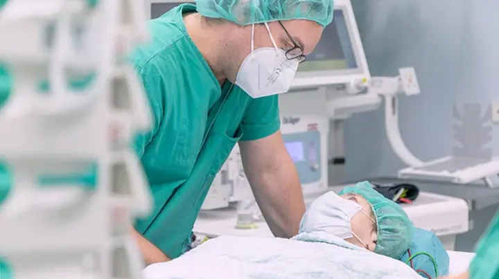 Oberarzt Christian Pistor spricht mit einer Patientin kurz vor ihrem Eingriff.  