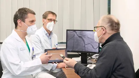 Beratungsgespräch zwischen zwei Ärzten der Kardiologie und einem Patienten