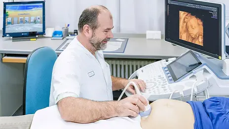 Dr. Wolfgang Köhler, Bereichsleiter Spezielle Geburtshilfe und Perinatalmedizin, untersucht eine schwangere Patientin mit einem Ultraschallgerät. 