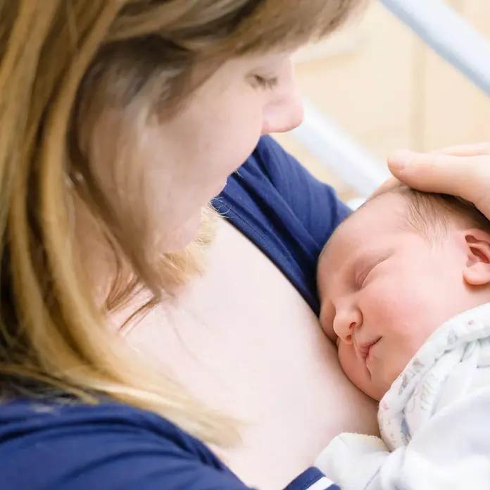 Neugeborenes Baby in den Armen der Mutter