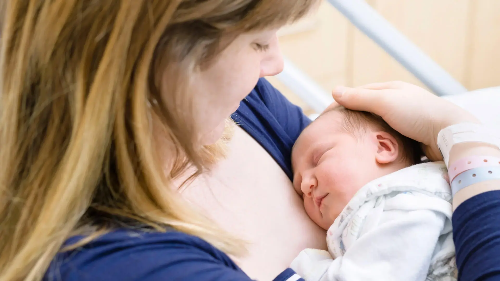 Neugeborenes Baby in den Armen der Mutter