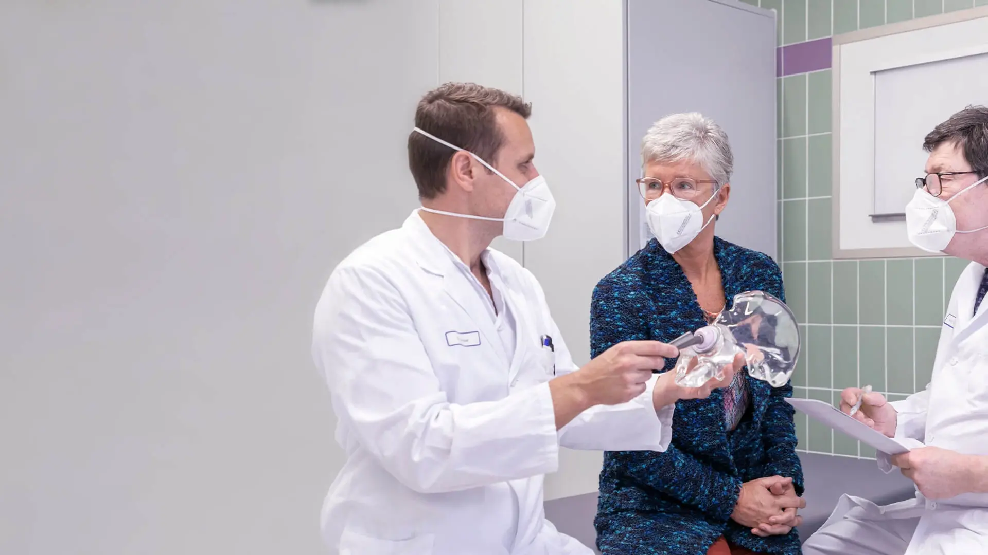 Prof. Dr. Dr. Michael Wagner, Abteilungsleiter Orthopädie und Endoprothetik, spricht gemeinsam mit einem Kollegen mit einer Patientin. 