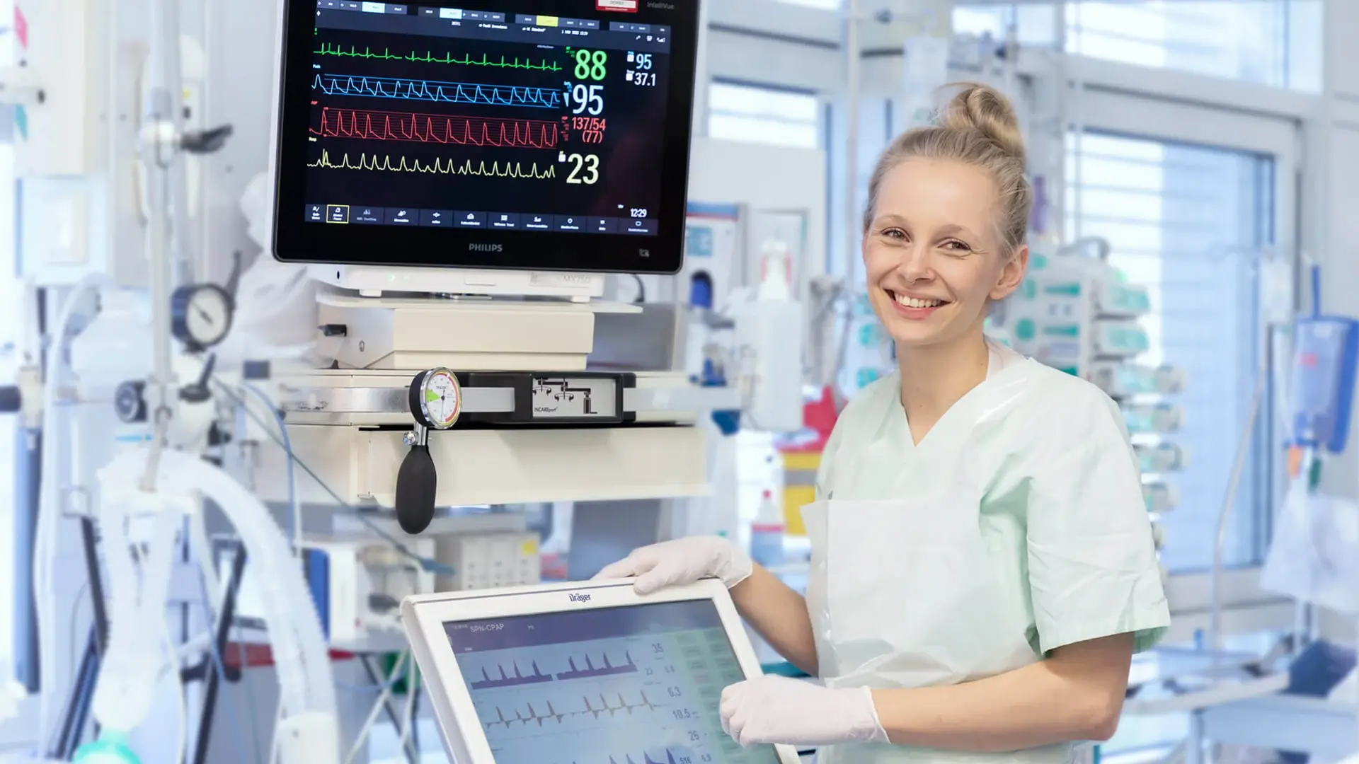 Eine Mitarbeitende der Intensivmedizin steht vor einem Monitor. 