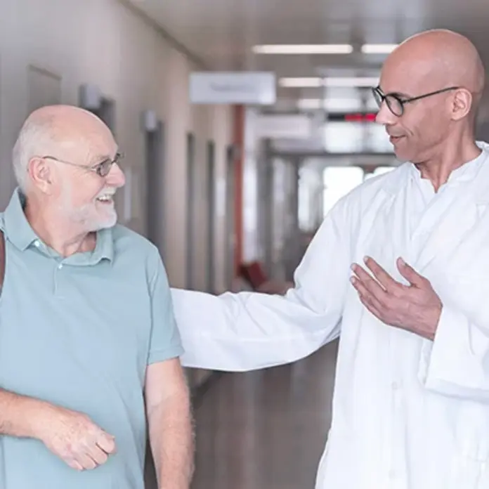 Ein Arzt verabschiedet einen Patienten nach einem erfolgreichen Eingriff. 