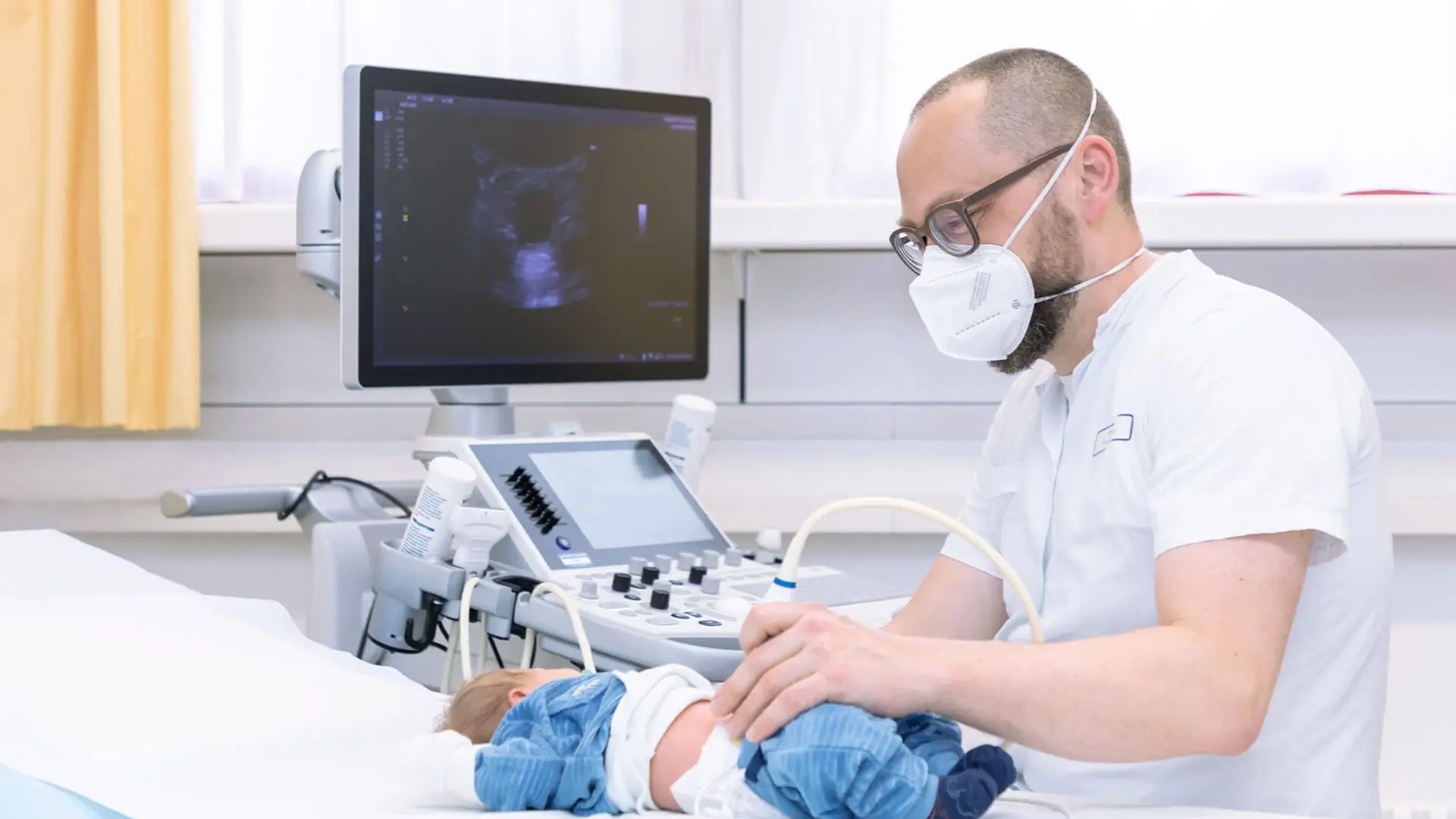 Ein Arzt führt eine Ultraschall Untersuchung am Bauch eines Babys durch