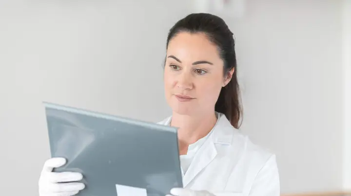  Ärztin hält Patientenakte in der Hand 