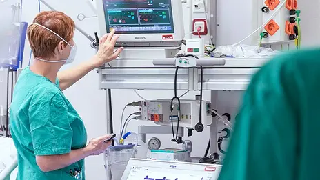 Eine Mitarbeiterin der Anästhesie bedient einen Monitor. 