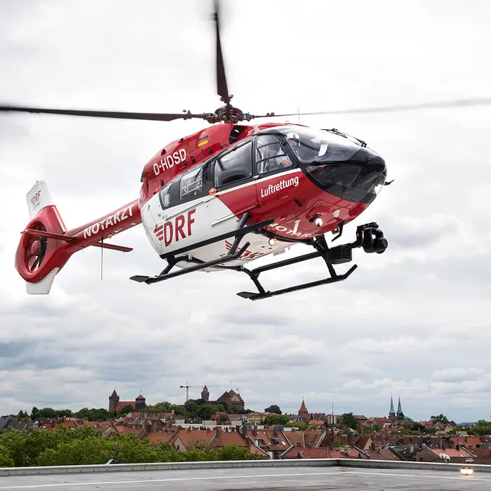 Auf dem Bild ist ein roter Helikopter zu sehen.