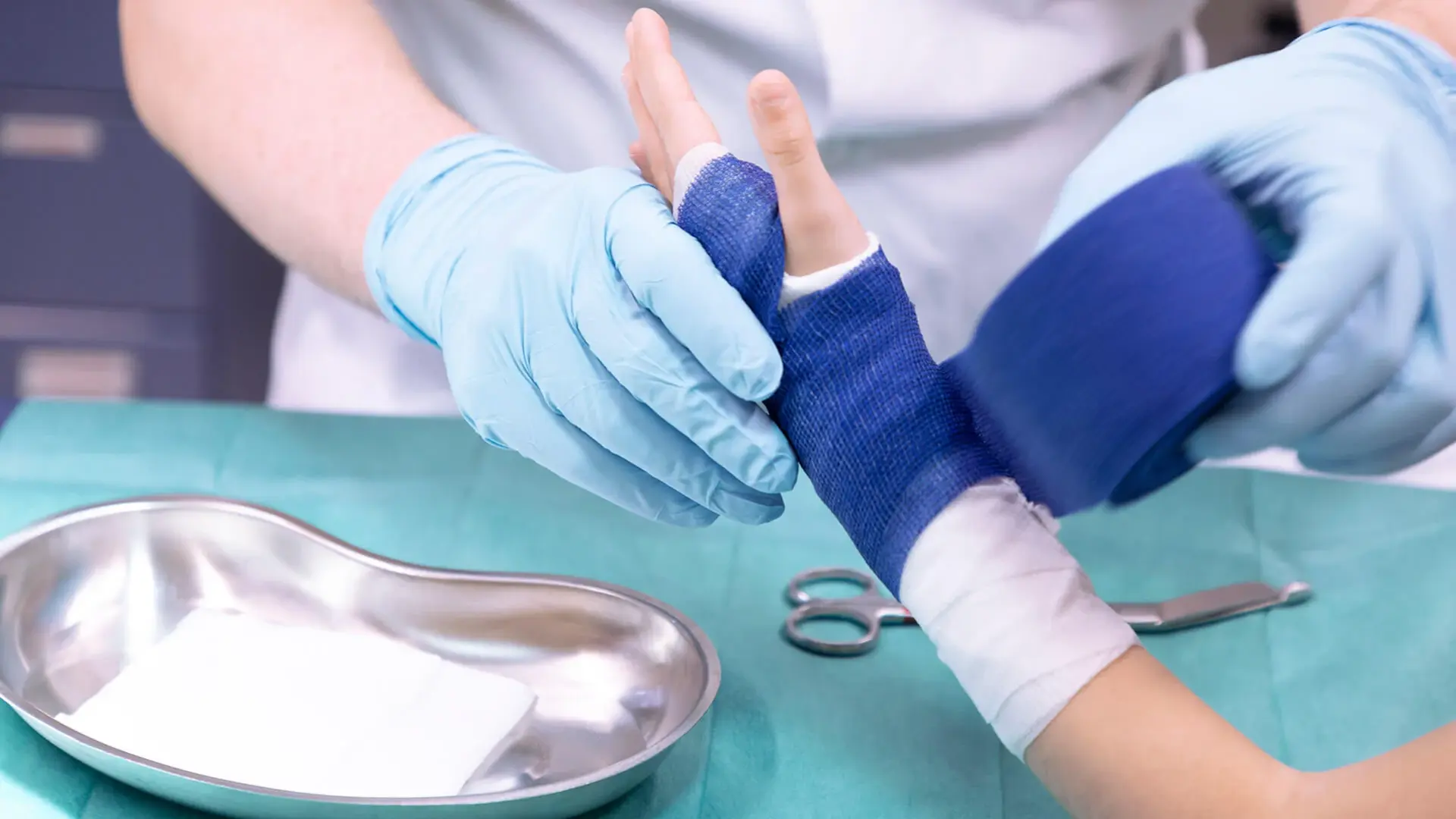 Medizinisches Personal vergipst die Hand eines Kindes