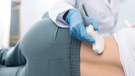 Ein Mitarbeitender der Nierenheilkunde untersucht die Niere einer Patientin mit einem Ultraschallgeräts. 