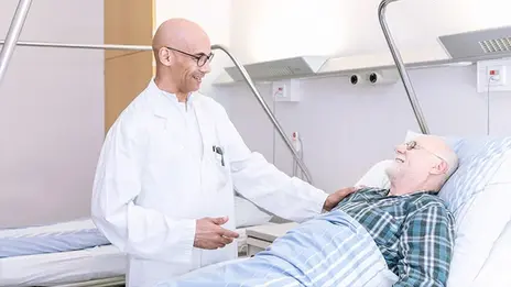 Arzt-Patienten-Gespräch, Patient liegt im Krankenhausbett