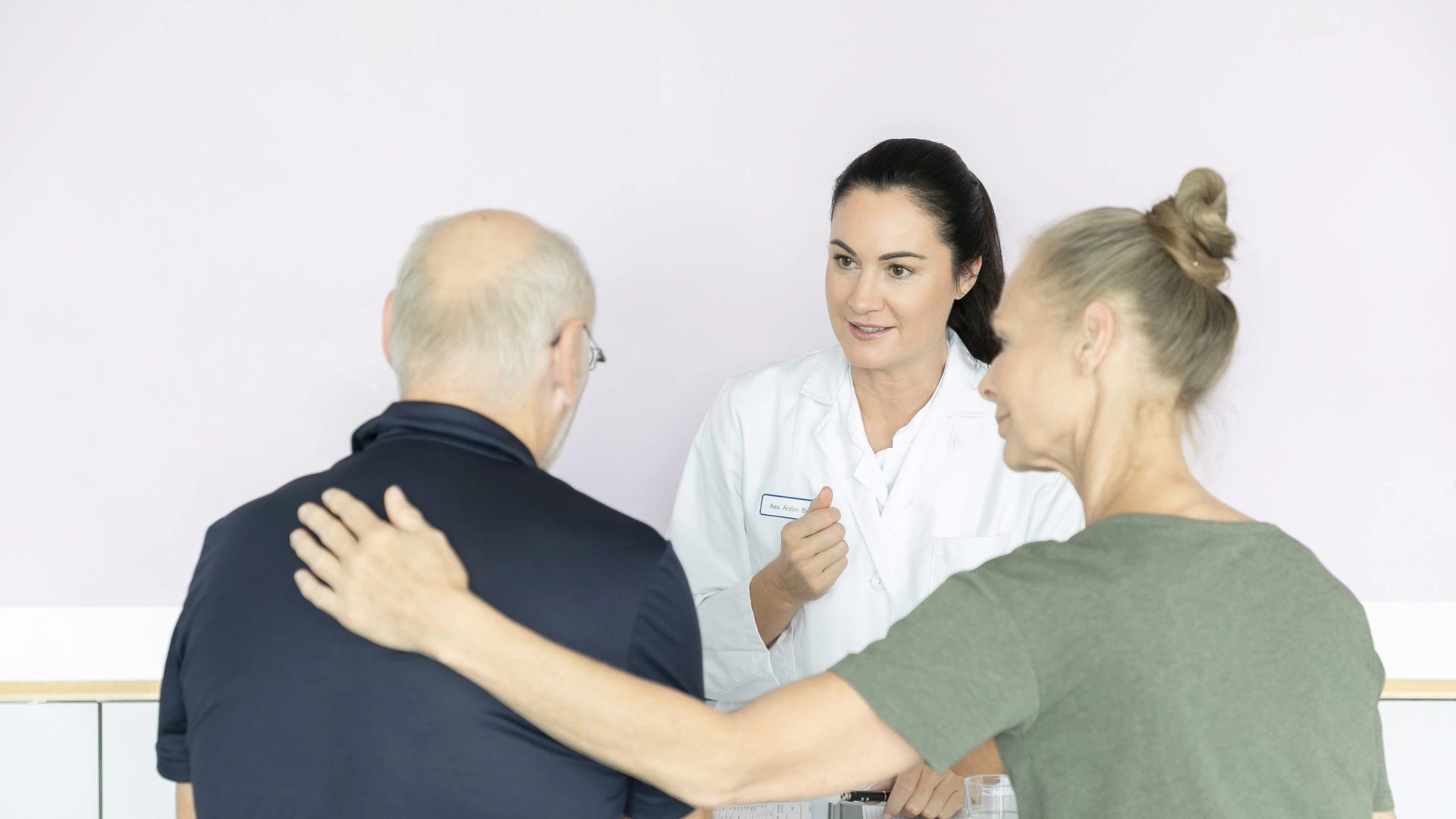 Eine Ärztin spricht mit einem männlichen Patienten. Die Gesprächssituation wirkt positiv. 