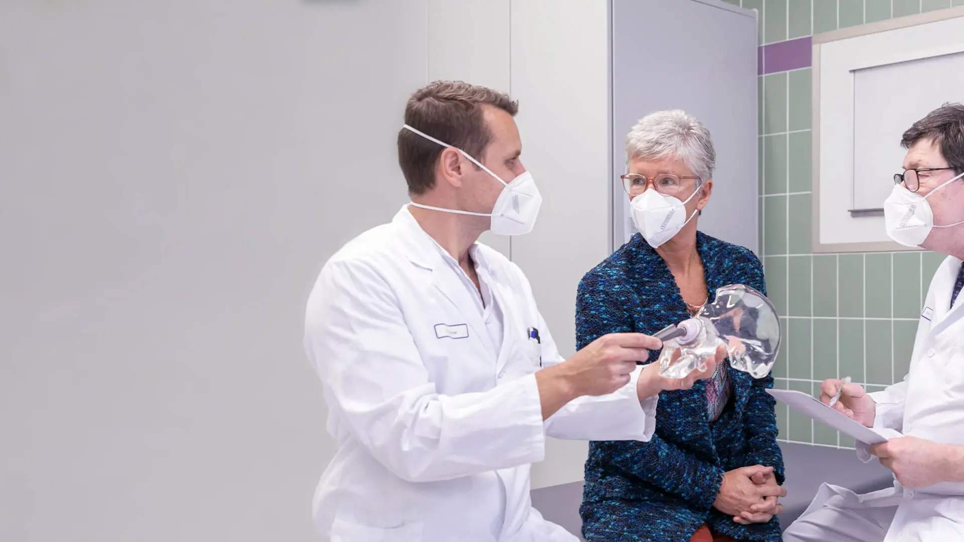 Prof. Dr. Dr. Michael Wagner, Abteilungsleiter Orthopädie und Endoprothetik, spricht gemeinsam mit einem Kollegen mit einer Patientin. 