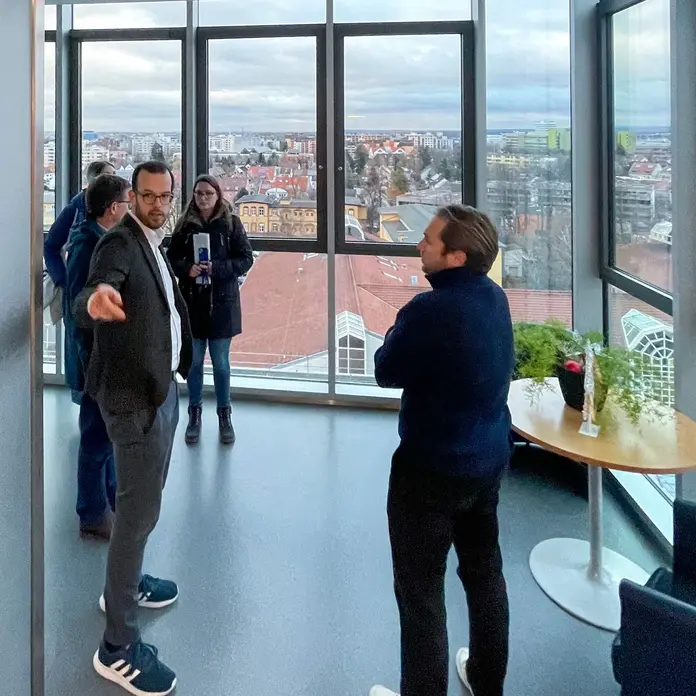 Auf dem Bild stehen Mitarbeitende des Klinikums auf einem Flur und betrachten die Räumlichkeiten. 