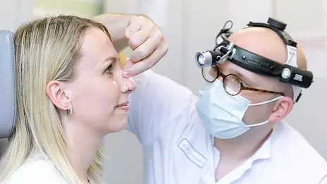PD Dr. med. Mirco Schapher, Oberarzt, untersucht die Nase einer jungen Patientin.