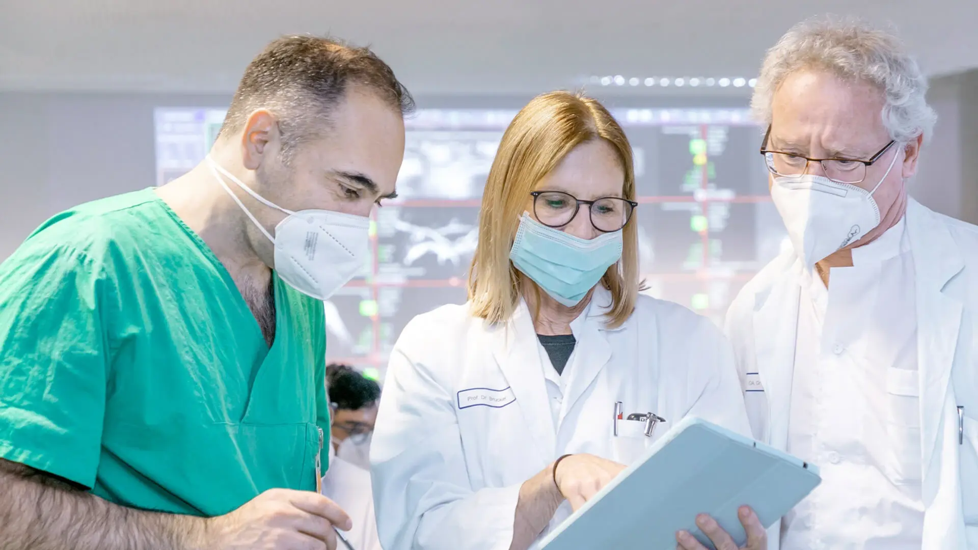 Drei Ärzte der Gynäkologie schauen gemeinsam auf ein Tablet
