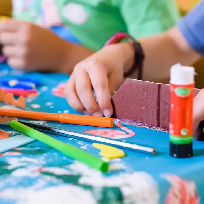 Kinder basteln auf einem Tisch.
