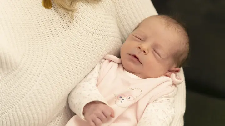 Neugeborenes Baby in den Armen der Mutter
