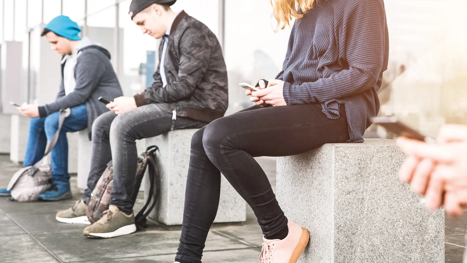 Drei Jugendliche mit Handy in der Hand während der Medientherapie