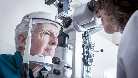 Eine Mitarbeiterin der Augenheilkunde führt eine Untersuchung bei einem Patienten durch. 