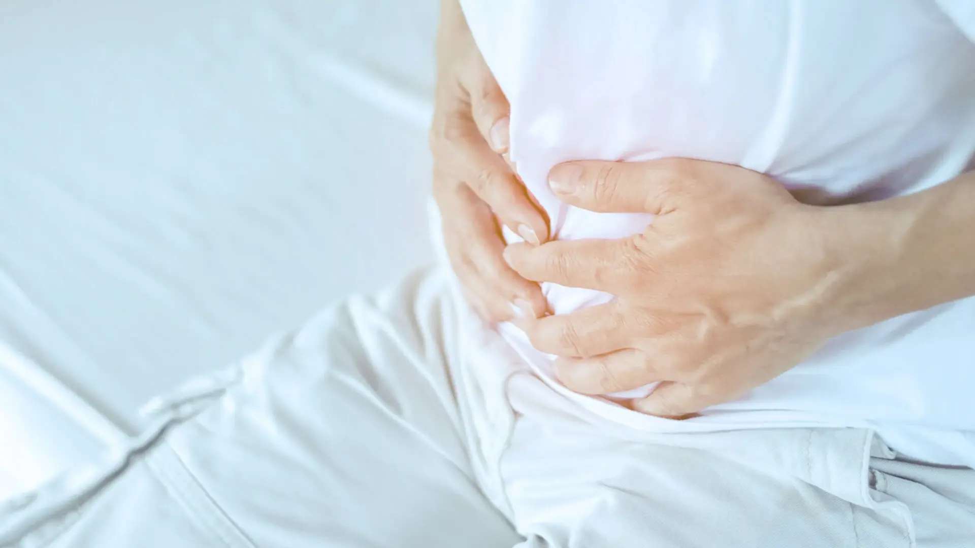 Das Symbolbild zeigt einen Mann, der sich den Bauch hält. Er hat offensichtlich Bauchschmerzen. 