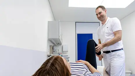 Prof. Dr. Markus Geßlein führt eine orthopädische Behandlung an einer Patientin durch.