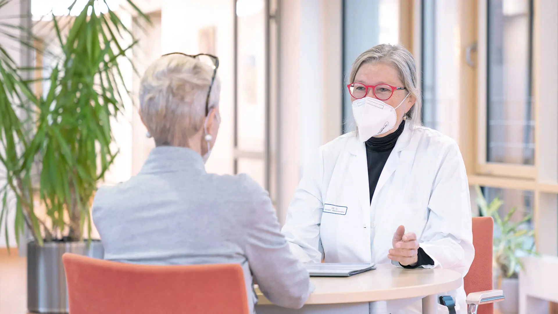 Eine Mitarbeitende der Palliativstation spricht mit einer Patientin. 