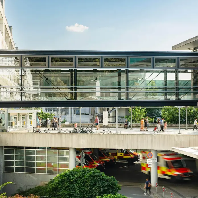 Klinikum Nürnberg Campus Süd, verglaster Übergang zum Herz-Gefäß-Zentrum. Unten sind Rettungswagen vor der Notaufnahme zu sehen.