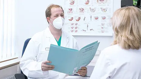 Ein Mitarbeiter der Urologie bespricht die Untersuchungsergebnisse mit einer Patientin. 