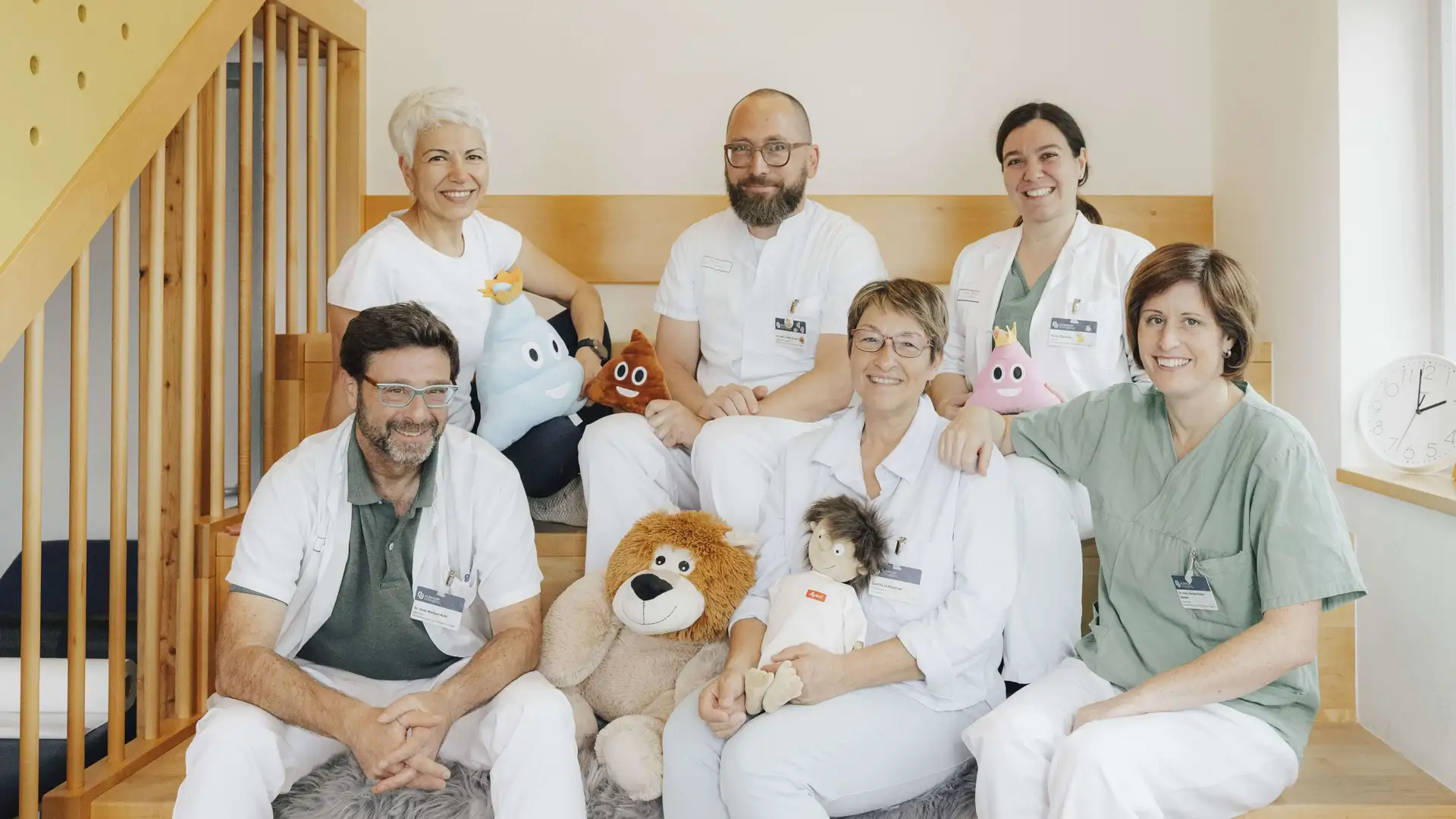Ein Gruppenbild mit den Mitarbeitenden der Kinderurologie. Sie sitzen auf einer Treppe.