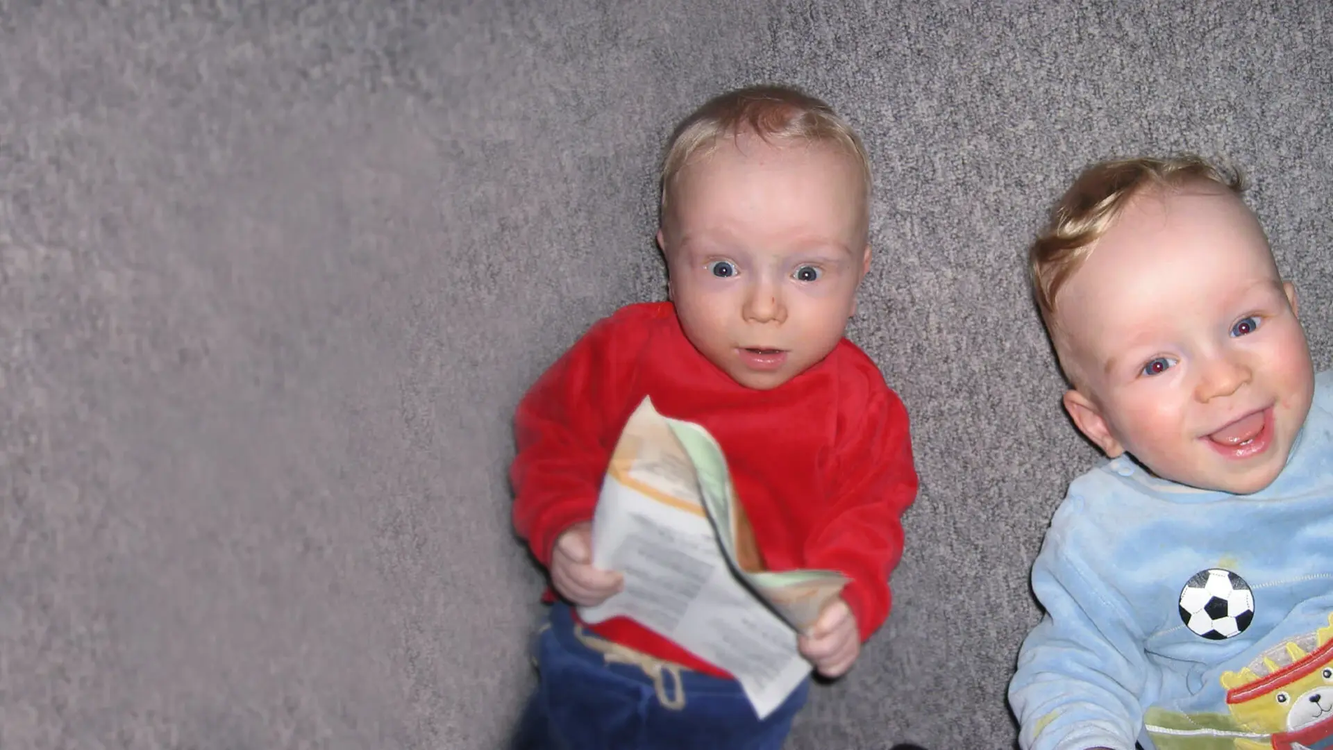 Die Babys Niels und Tom liegen zusammen auf einer Kuscheldecke.