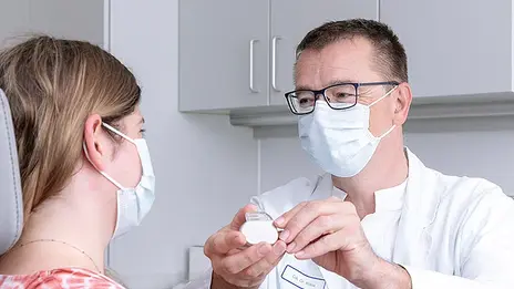 Unser Arzt erklärt einer Patientin einen Zungenschrittmacher. 