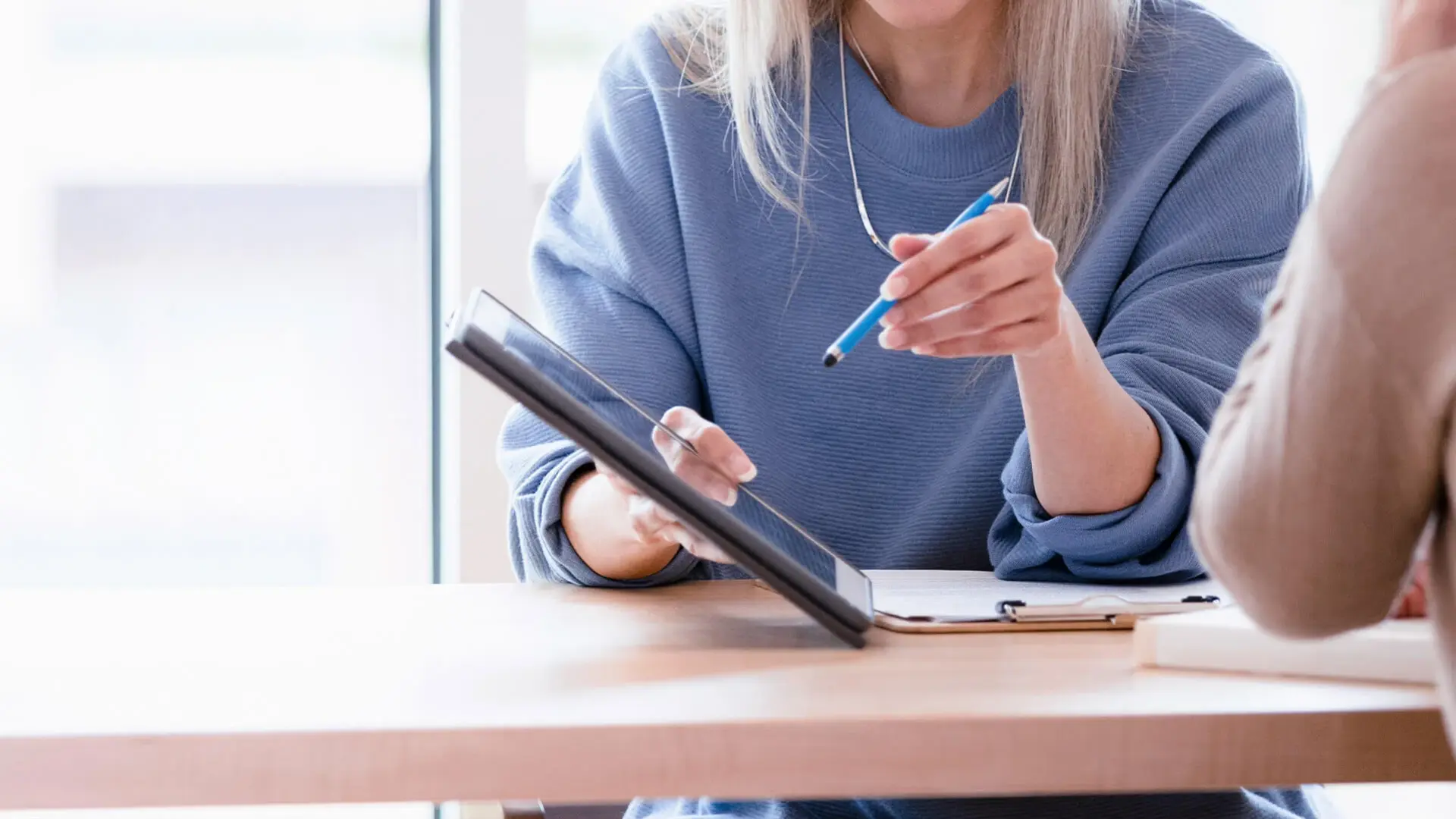 Eine Mitarbeiterin der Psychosomatik erklärt einer Patientin etwas auf dem Ipad. 