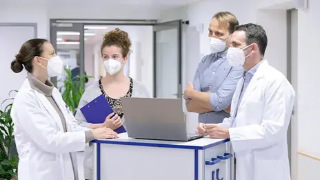 Vier Mitarbeitende der Psychiatrie beraten sich.