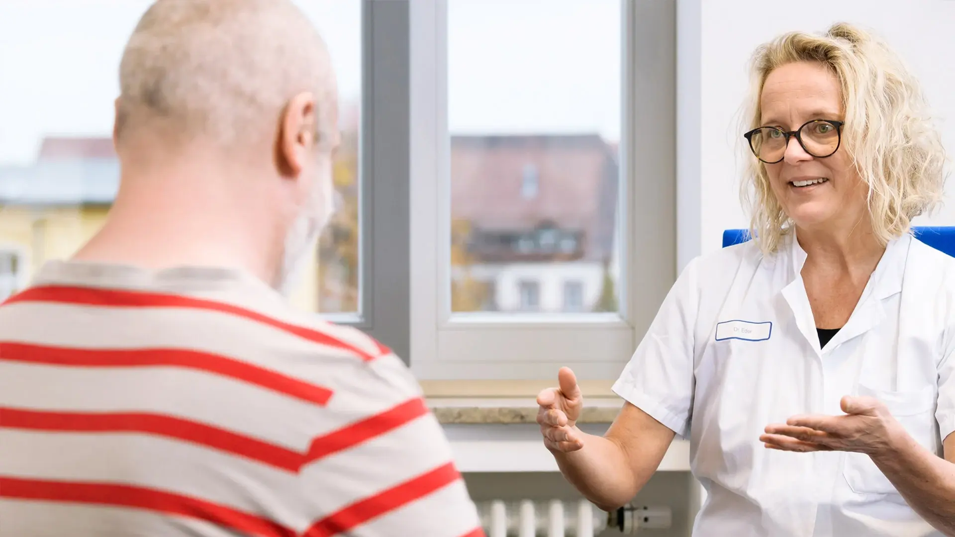 Fachärztin des Schmerzzentrums Dr. med. Susanne Eder spricht mit einem Patienten.