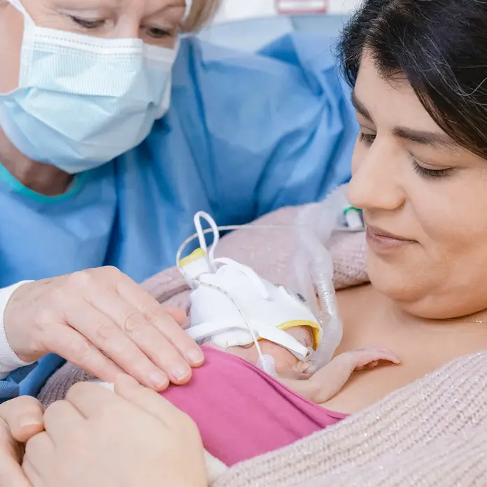 Frühgeborenes auf der Brust der Mutter 