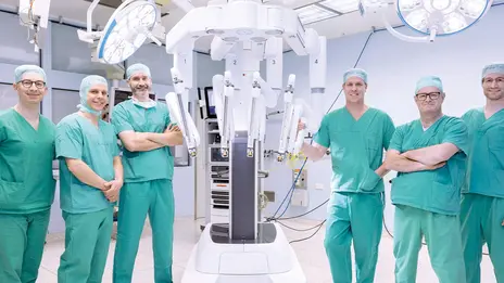 Ärzte stehen im OP-Saal um den neuen Da-Vinci-Roboter.