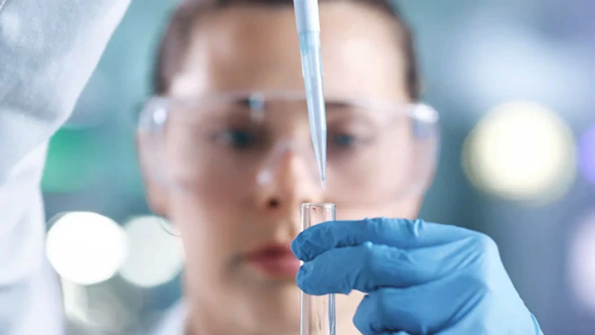 Eine Mitarbeitende füllt mittels Pipette ein Reagenzglas.