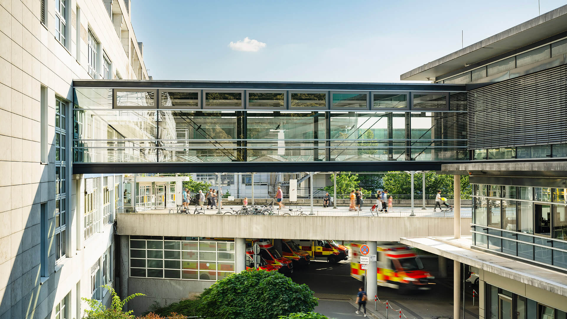 Klinikum Nürnberg Campus Süd, verglaster Übergang zum Herz-Gefäß-Zentrum. Unten sind Rettungswagen vor der Notaufnahme zu sehen.