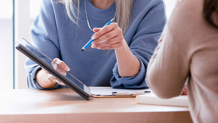 Eine Mitarbeiterin der Psychosomatik erklärt einer Patientin etwas auf dem Ipad. 