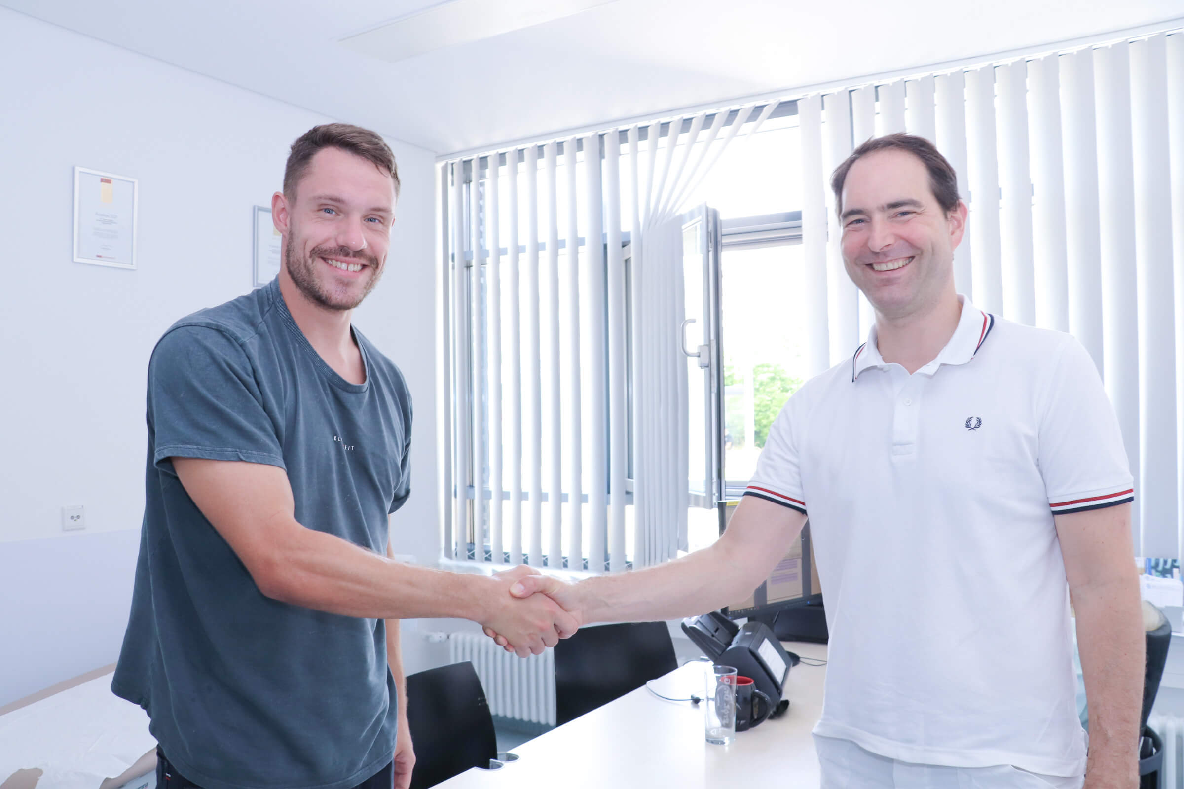 Prof. Gesslein und der Club-Spieler geben sich die Hand.