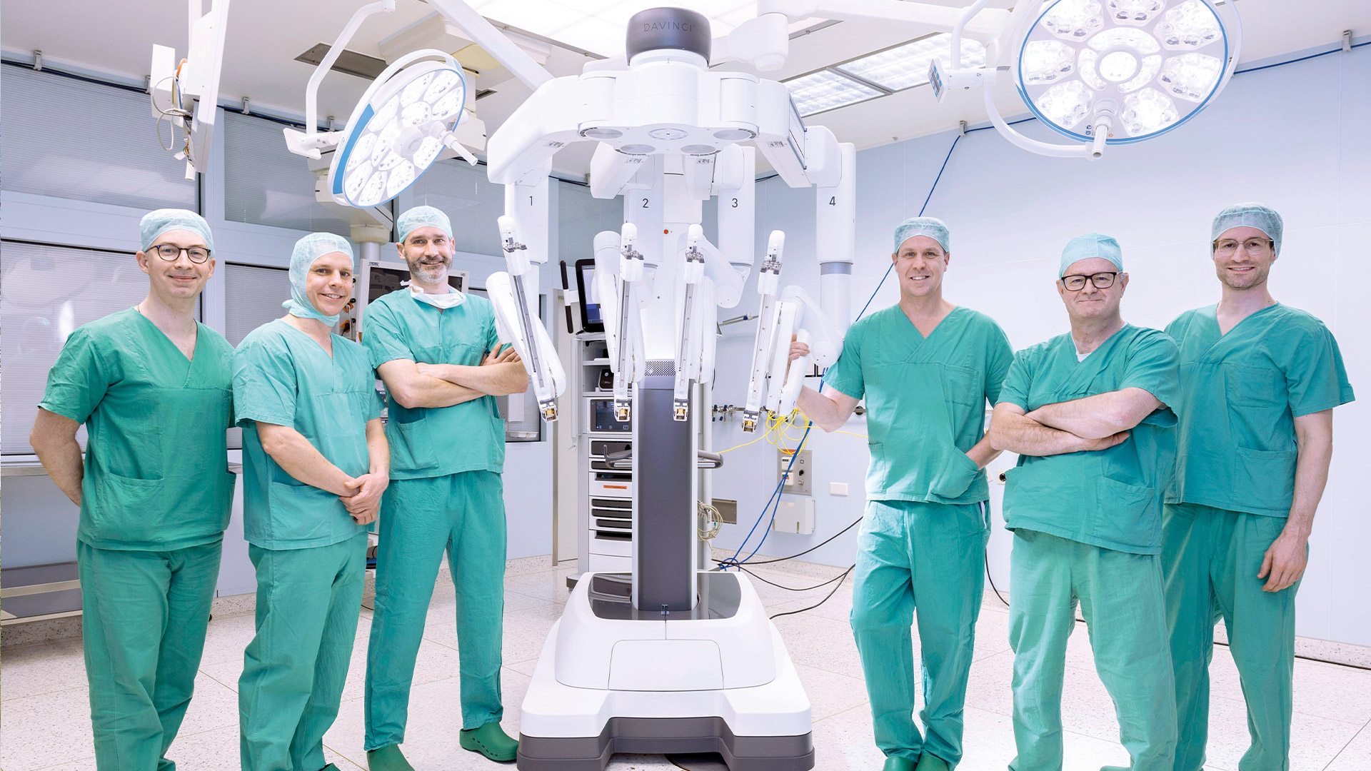 Ärzte stehen im OP-Saal um den neuen Da-Vinci-Roboter.